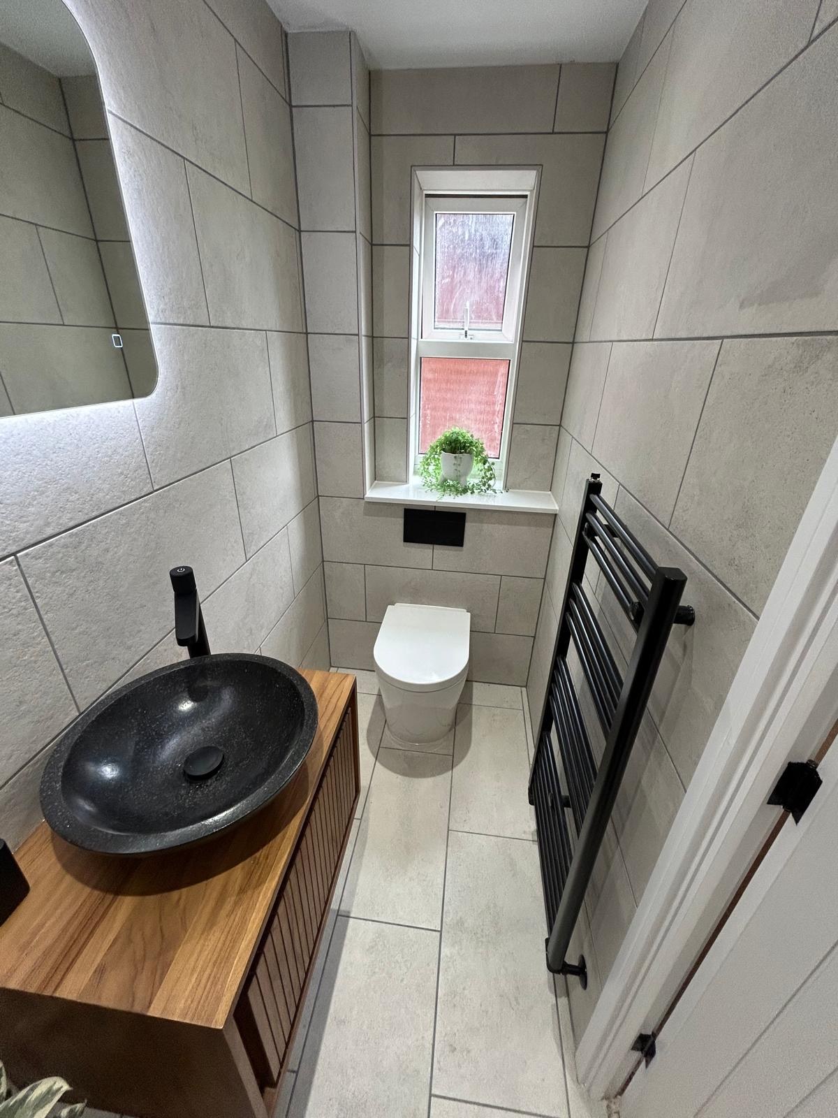 Contemporary cloakroom with black heated towel rail