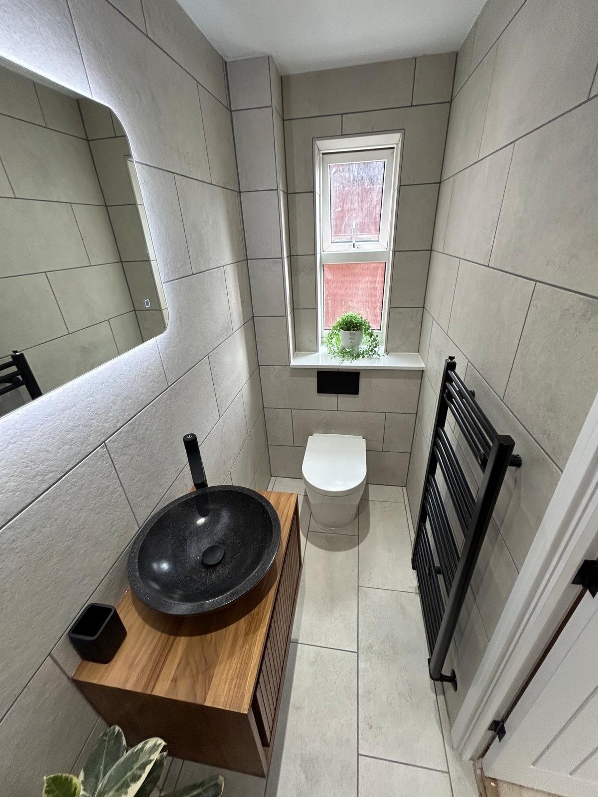 Cloakroom with stone vessel basin and oak vanity, overhead