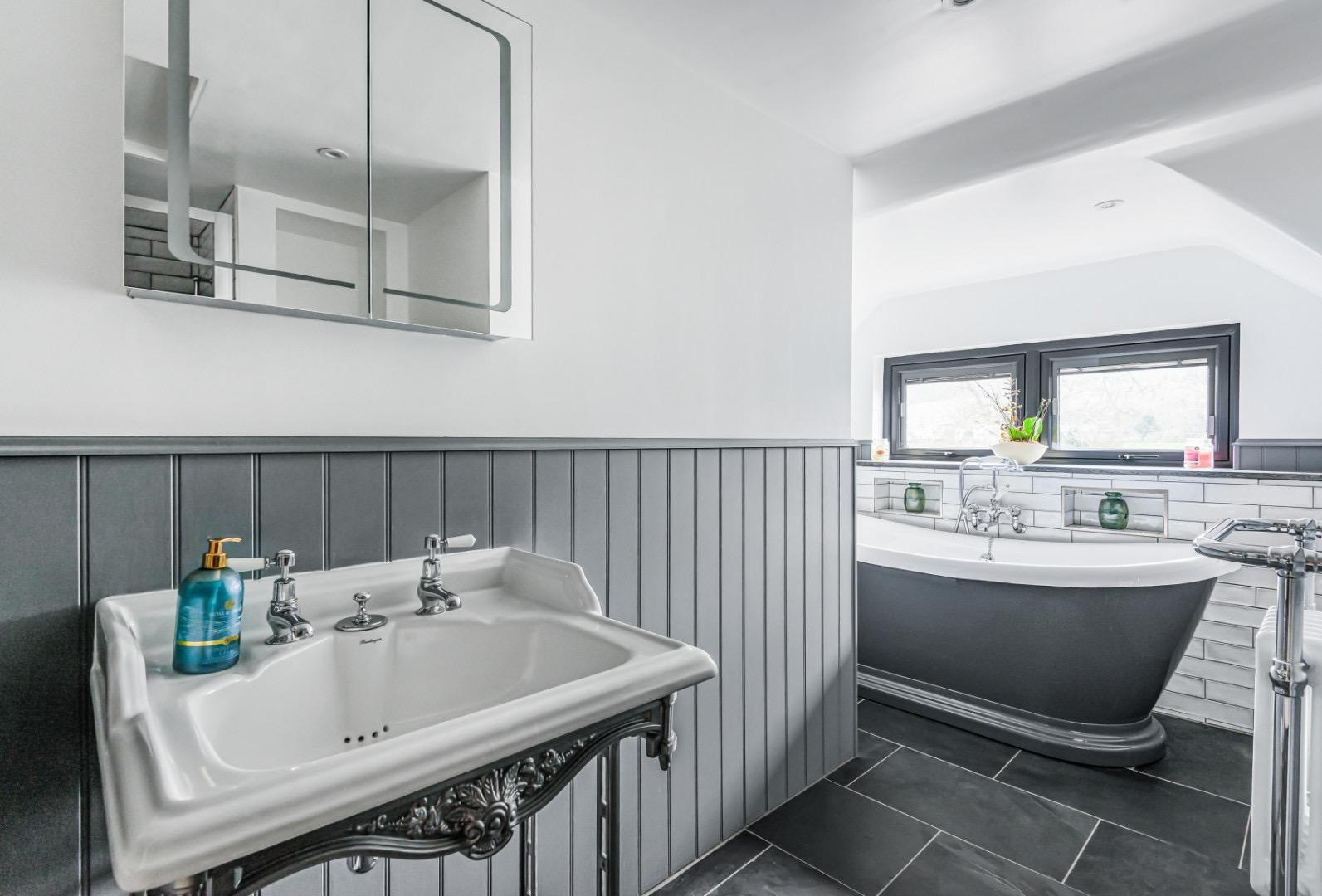 Soft grey bathroom with freestanding slipper bath