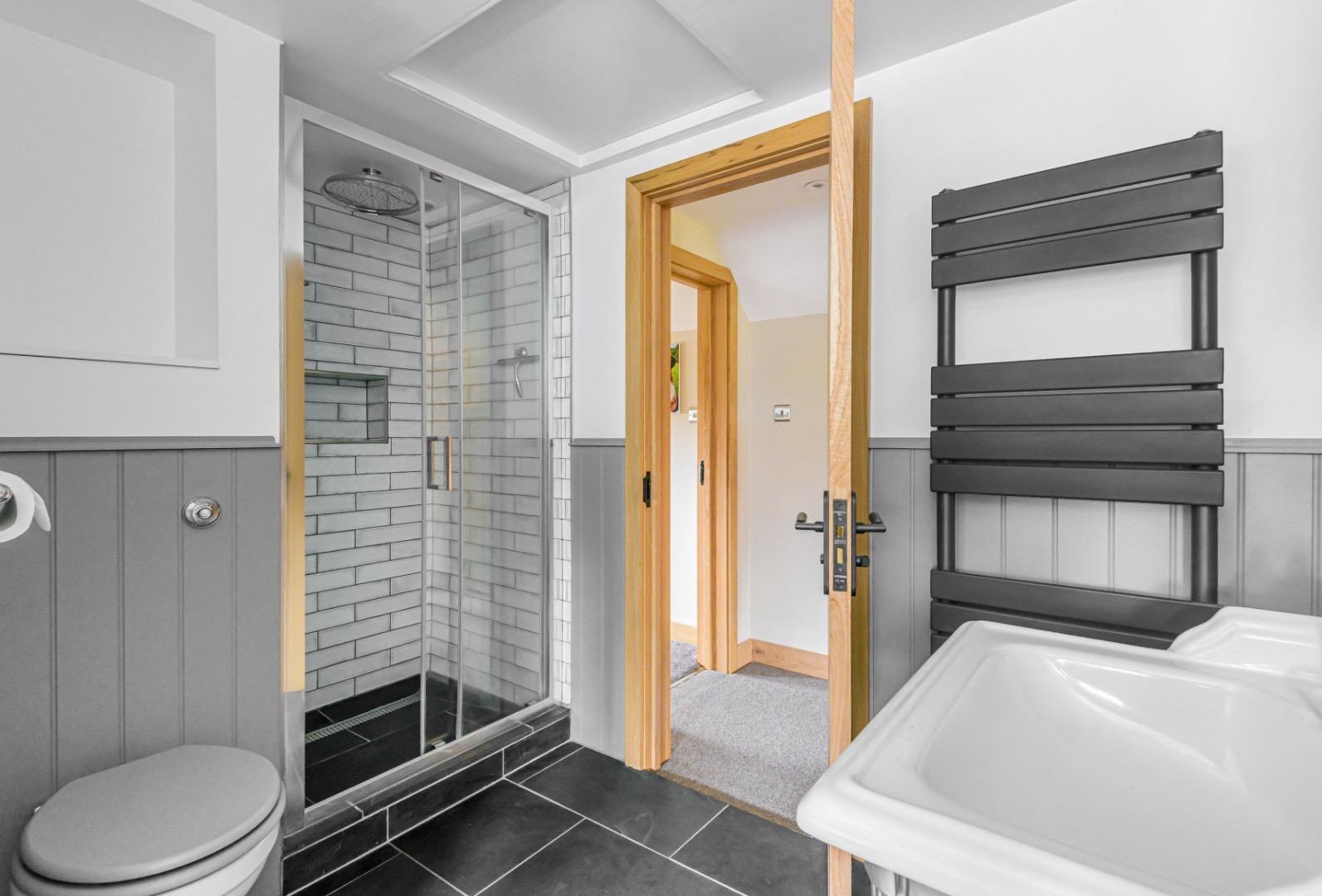 Soft grey shower room with metro enclosure and heated towel rail