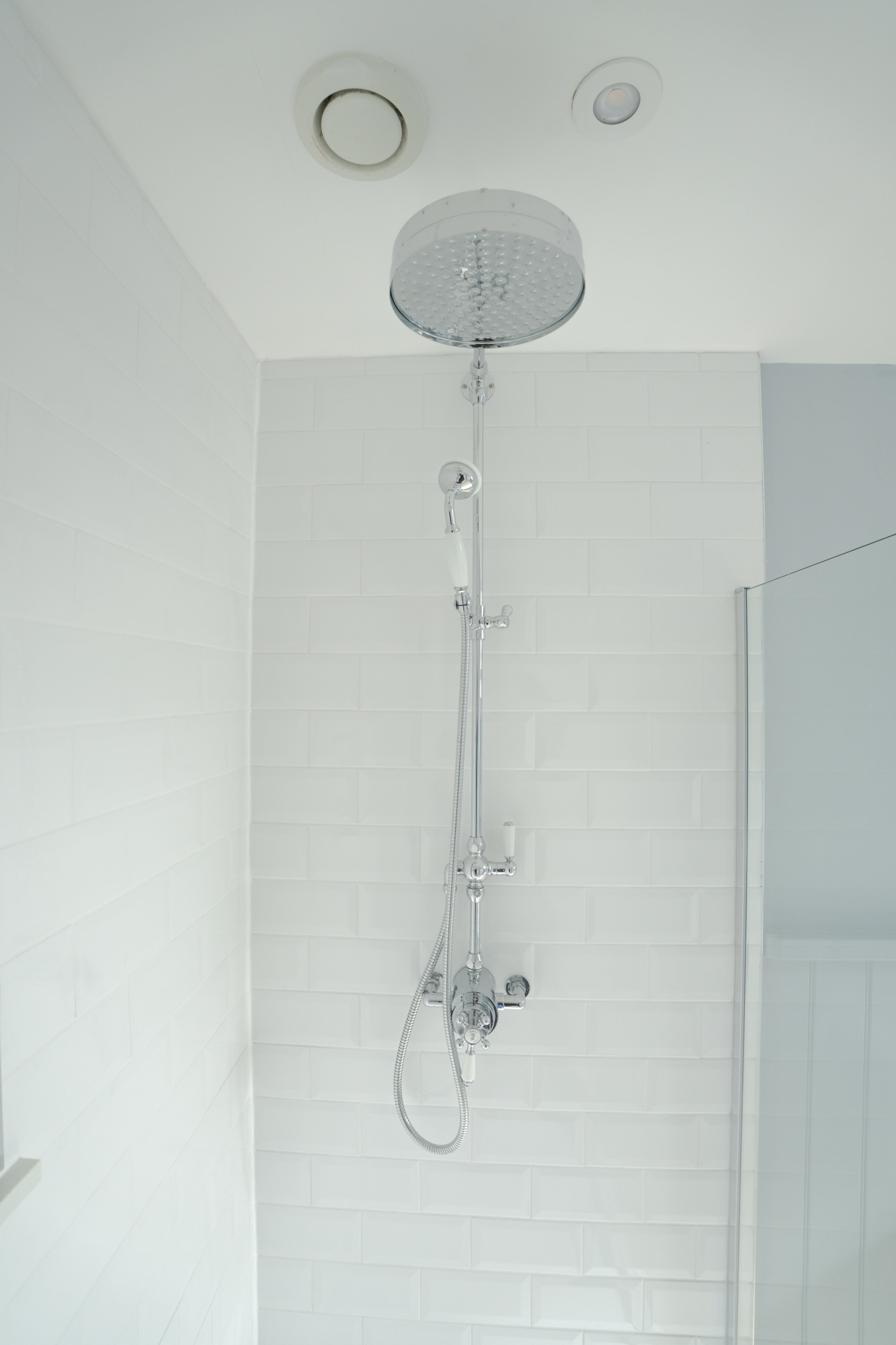 Traditional chrome shower column on metro tile
